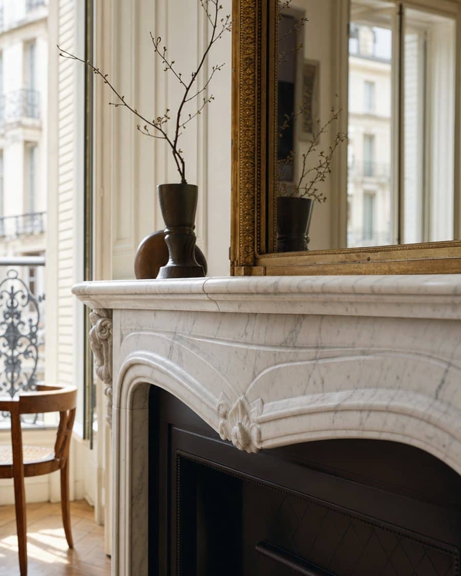 Cheminée en marbre blanc sculpté et miroir doré dans un salon haussmannien